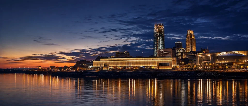 Downtown Omaha skyline at dusk reflected across the Missouri River